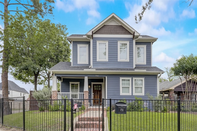 craftsman-style house with a porch, a shingled roof, a fenced front yard, and a front yard