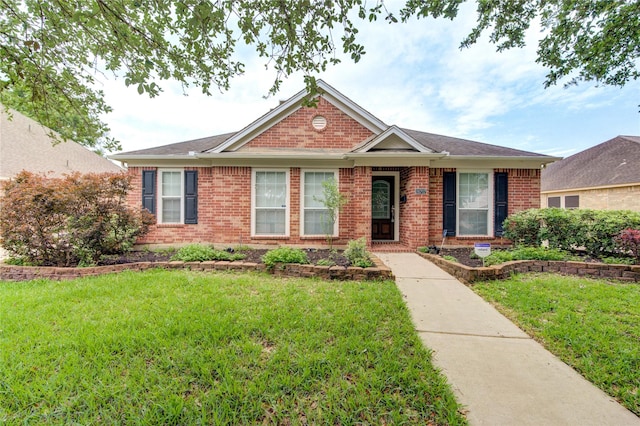 view of front facade with brick siding and a front yard