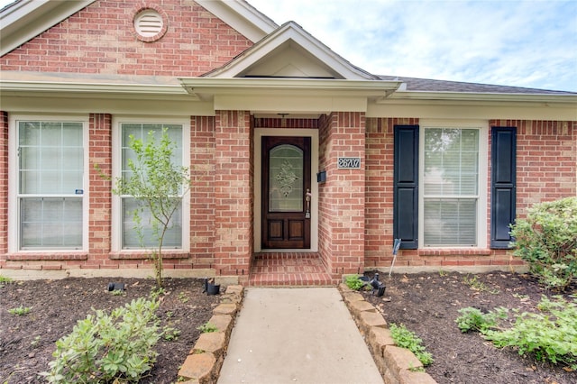 doorway to property featuring brick siding