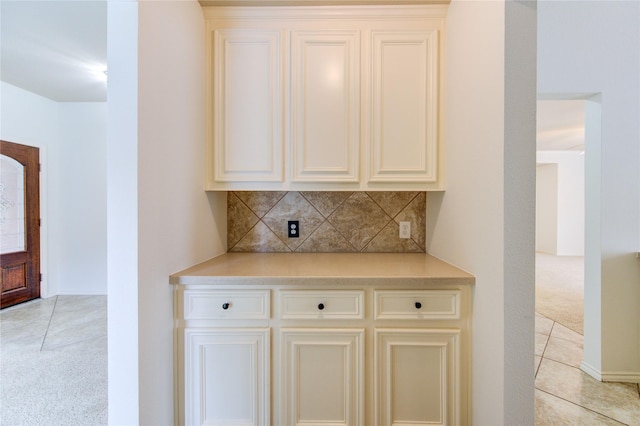 bar with backsplash, light carpet, and light tile patterned floors