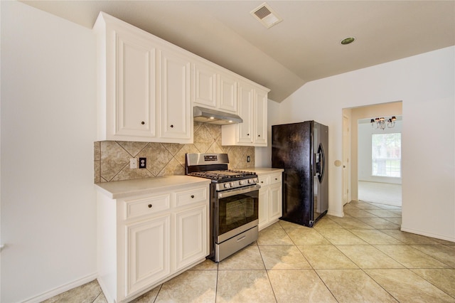 kitchen featuring backsplash, black fridge with ice dispenser, stainless steel gas range, a notable chandelier, and under cabinet range hood