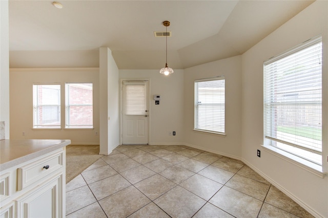 foyer with light tile patterned floors, baseboards, lofted ceiling, and visible vents