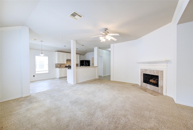 unfurnished living room featuring visible vents, light carpet, baseboards, ceiling fan, and a tiled fireplace
