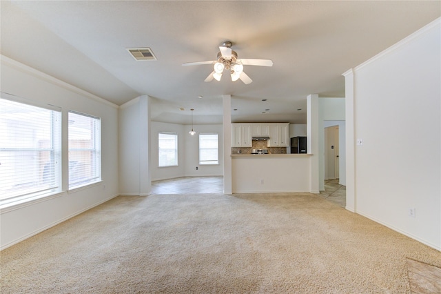unfurnished living room with baseboards, light carpet, a ceiling fan, and visible vents