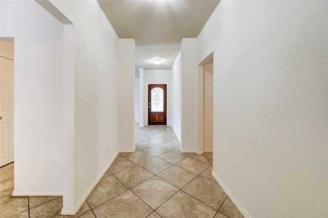 hall with baseboards and light tile patterned flooring