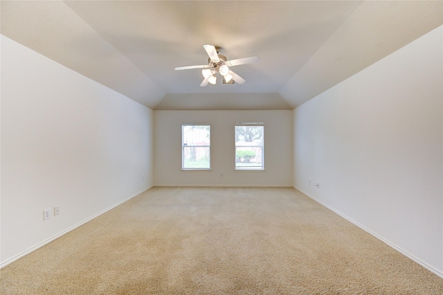 spare room featuring ceiling fan, light colored carpet, and baseboards