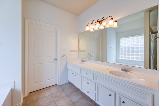full bath featuring double vanity, tile patterned floors, a sink, and a tub to relax in