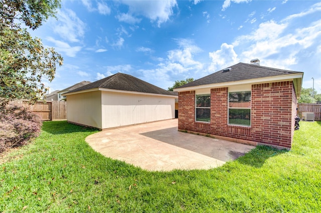 rear view of house featuring fence, a lawn, cooling unit, and a patio area