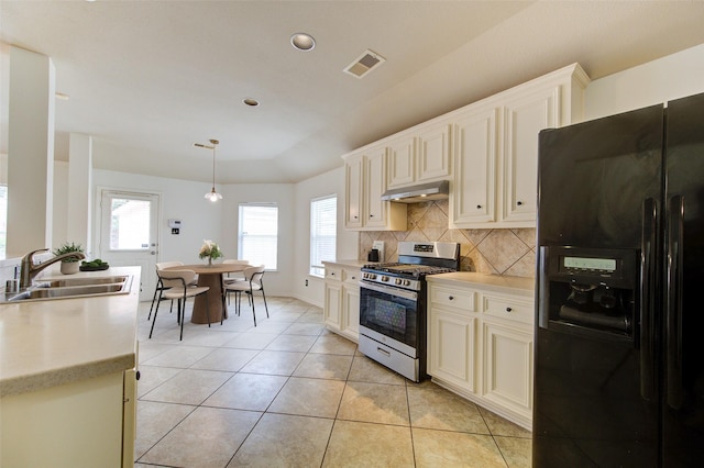 26707 Abbey Springs Ln, Katy, TX 77494 - kitchen featuring stainless steel gas range, a sink, black refrigerator with ice dispenser, under cabinet range hood, and visible vents