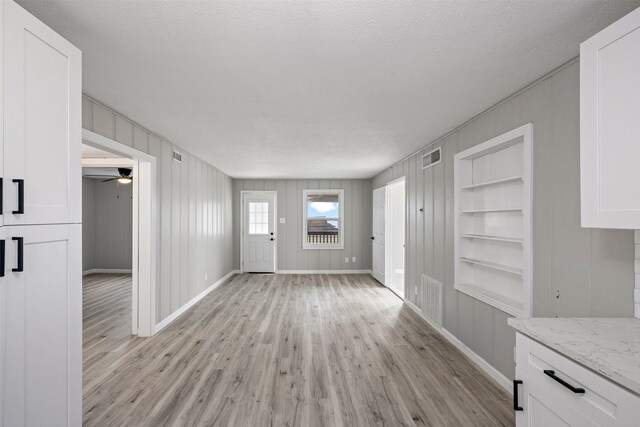 entryway with baseboards, light wood-style flooring, and visible vents