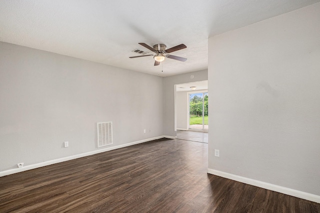 empty room featuring visible vents, dark wood finished floors, ceiling fan, and baseboards