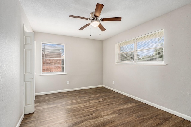 empty room featuring baseboards, dark wood finished floors, and ceiling fan