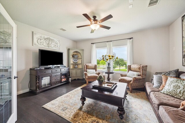 living area featuring baseboards, ceiling fan, dark wood finished floors, and visible vents