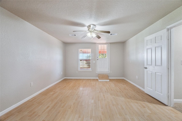 unfurnished room with a ceiling fan, baseboards, visible vents, and light wood-style flooring