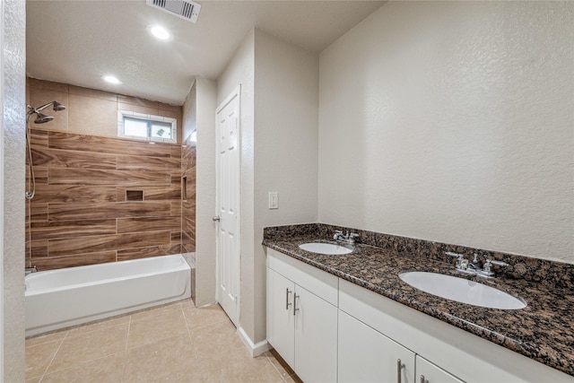 bathroom featuring a sink, tile patterned flooring, a textured wall, and visible vents