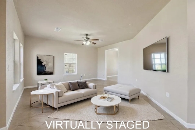 tiled living area with baseboards, ceiling fan, visible vents, and a wealth of natural light