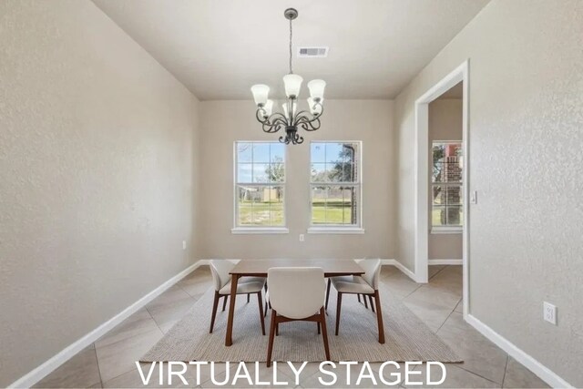 dining area with light tile patterned flooring, a textured wall, a notable chandelier, and visible vents