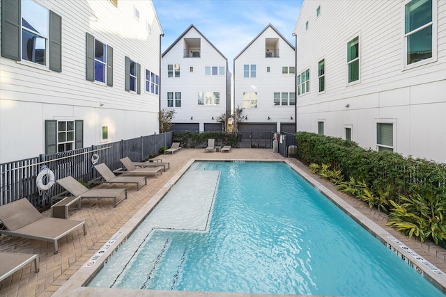 community pool with fence and a patio