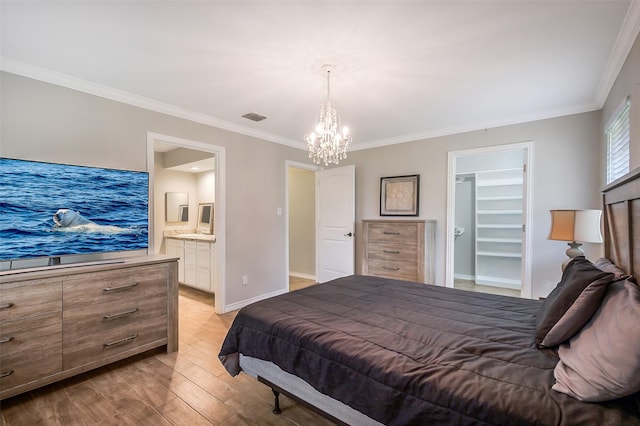 bedroom with crown molding, a notable chandelier, a walk in closet, light wood finished floors, and visible vents
