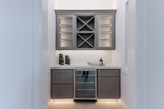 bar with baseboards, a dry bar, and wine cooler