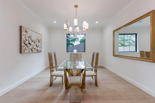 dining space with baseboards, a notable chandelier, ornamental molding, and light wood-type flooring