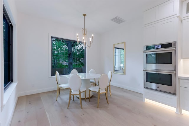 dining area with an inviting chandelier, plenty of natural light, visible vents, and light wood-style floors