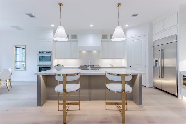 kitchen featuring appliances with stainless steel finishes, custom exhaust hood, and visible vents