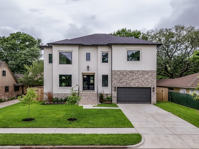 contemporary home featuring a garage, fence, a front yard, stone siding, and stucco siding