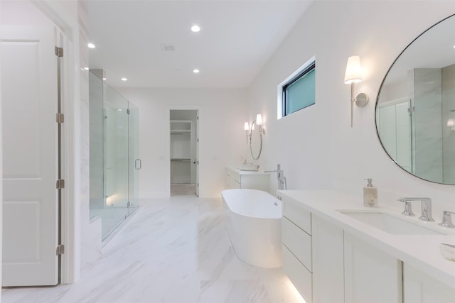 full bath featuring recessed lighting, a freestanding tub, a sink, and a stall shower