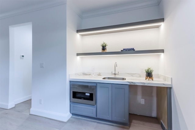 bar featuring ornamental molding, baseboards, stainless steel oven, a sink, and wet bar