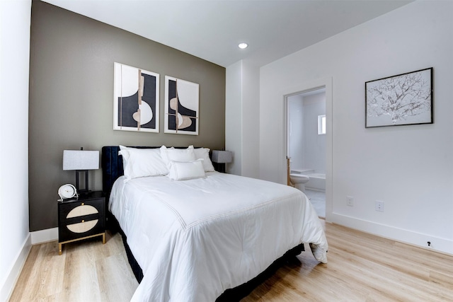 bedroom featuring recessed lighting, baseboards, light wood finished floors, and ensuite bath