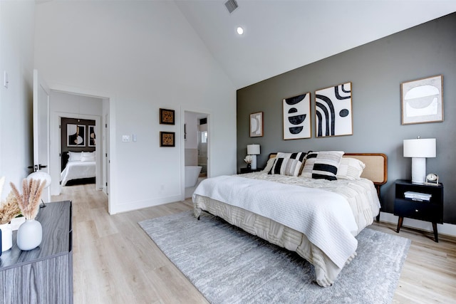 bedroom featuring high vaulted ceiling, baseboards, light wood finished floors, and visible vents