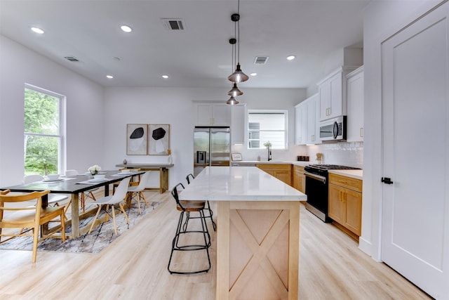 kitchen featuring appliances with stainless steel finishes, a wealth of natural light, and visible vents