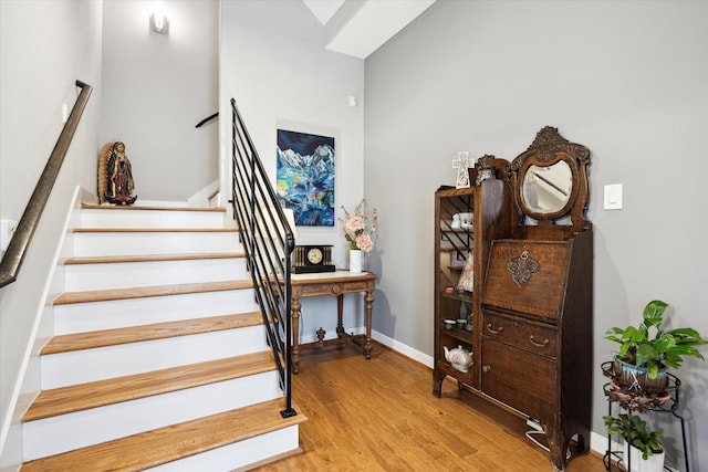 stairs with baseboards and wood finished floors