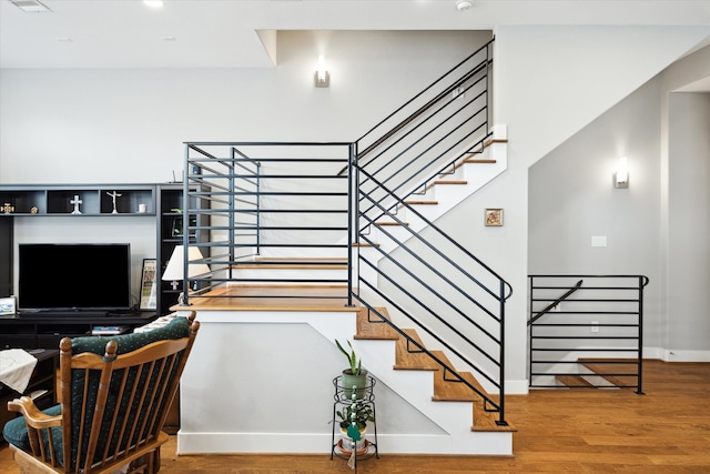 stairs featuring baseboards, visible vents, and wood finished floors