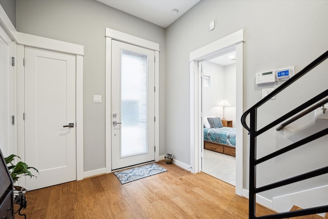 entryway featuring a healthy amount of sunlight, baseboards, and light wood-style flooring