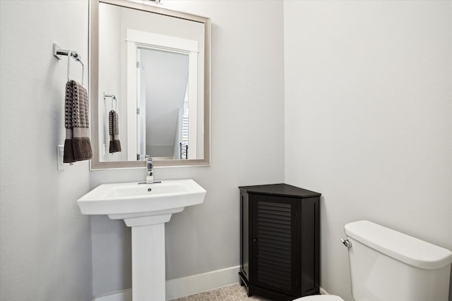 bathroom with baseboards and toilet