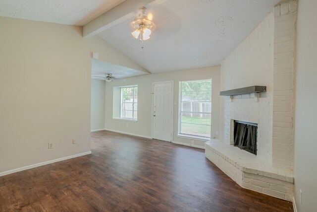 unfurnished living room featuring lofted ceiling with beams, a fireplace, a ceiling fan, and dark wood finished floors