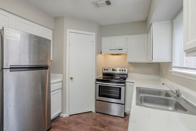 kitchen with visible vents, white cabinetry, under cabinet range hood, a sink, and appliances with stainless steel finishes