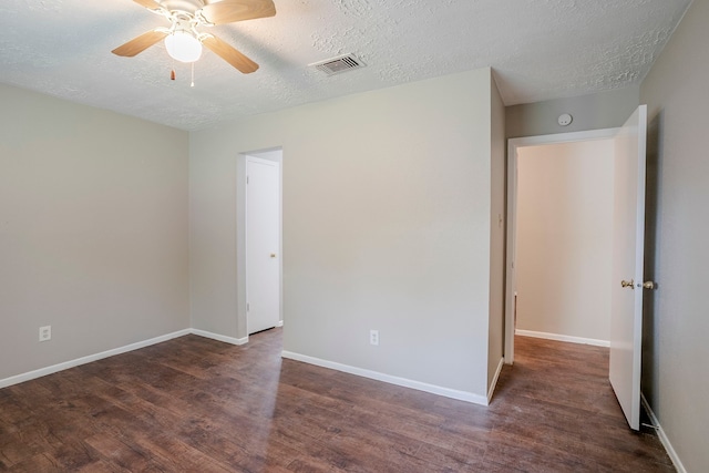 spare room with a ceiling fan, a textured ceiling, visible vents, and wood finished floors