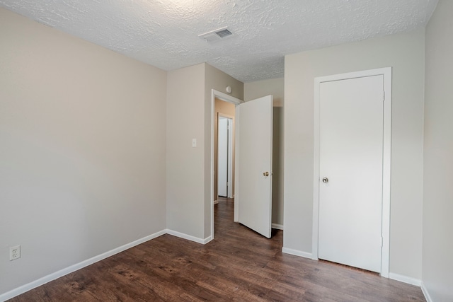 4523 Towergate Dr, Spring, TX 77373 - unfurnished bedroom featuring dark wood-style floors, baseboards, and a textured ceiling