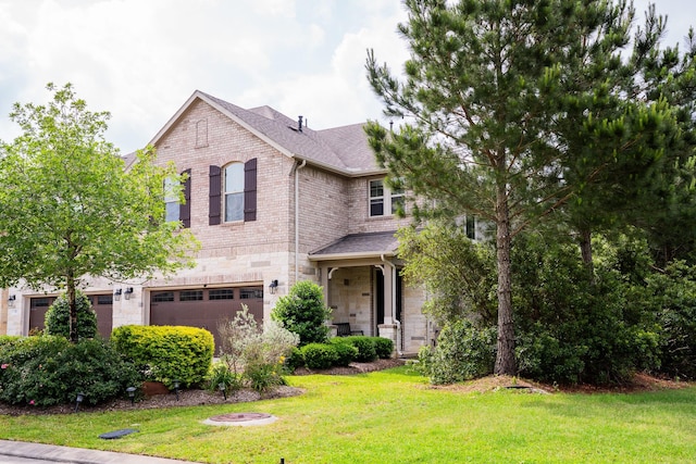 view of front of home featuring a garage, stone siding, a front yard, roof with shingles, and brick siding