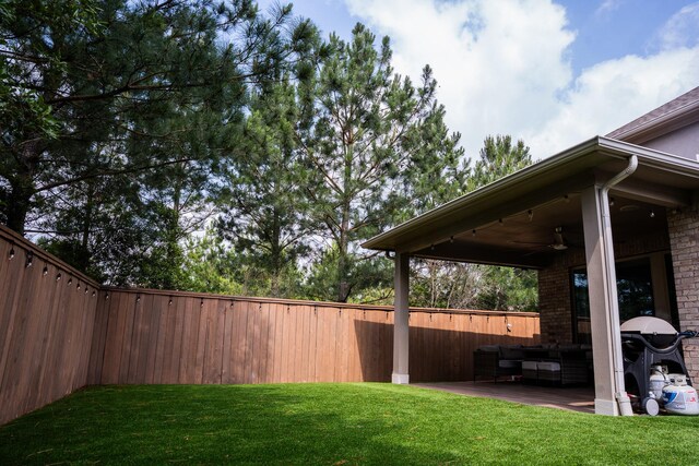 view of yard with a fenced backyard, a ceiling fan, an outdoor hangout area, and a patio area