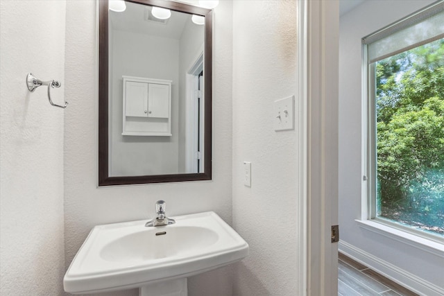 26 Heirloom Garden Pl, Magnolia, TX 77354 - bathroom with a sink, wood finished floors, baseboards, and a textured wall