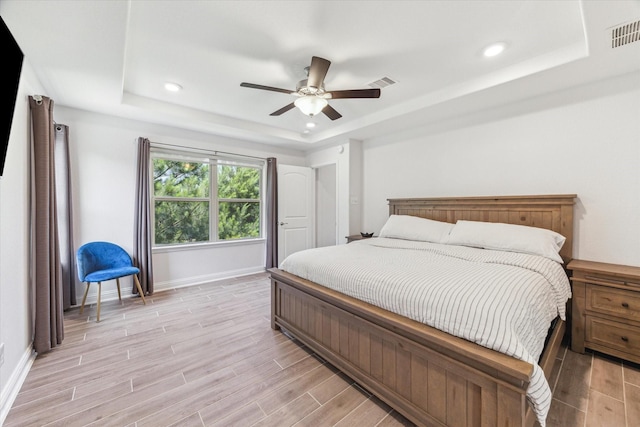 26 Heirloom Garden Pl, Magnolia, TX 77354 - bedroom with a tray ceiling, light wood-style floors, baseboards, a ceiling fan, and recessed lighting