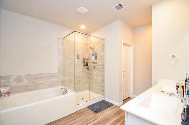 12630 Beddington Ct, Tomball, TX 77375 - bathroom featuring wood finished floors, double sink, visible vents, a bath, and a stall shower