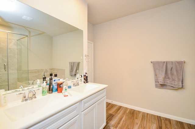 12630 Beddington Ct, Tomball, TX 77375 - full bathroom with a sink, double vanity, a shower with door, and wood finished floors