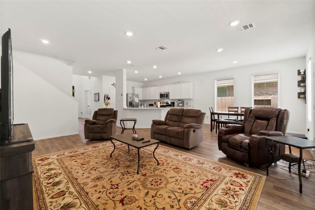 living room with visible vents, recessed lighting, and light wood-type flooring