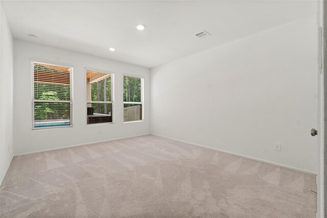 carpeted empty room featuring recessed lighting, baseboards, and visible vents