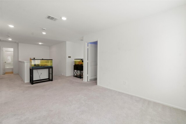 unfurnished living room featuring recessed lighting, baseboards, visible vents, and light carpet